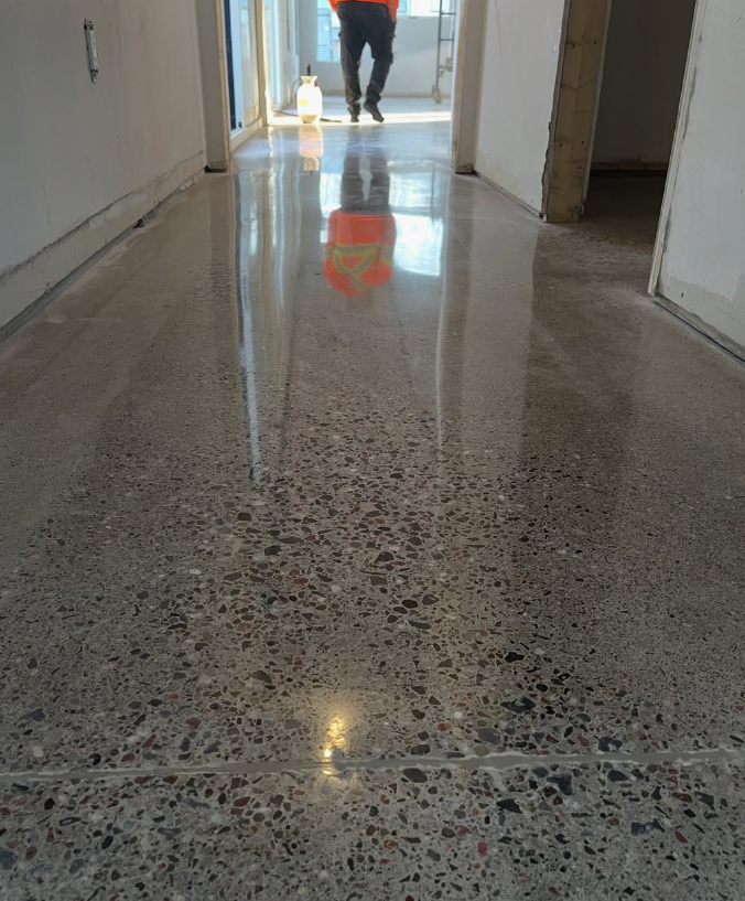 Polished concrete hallway with exposed aggregate and mirror reflection