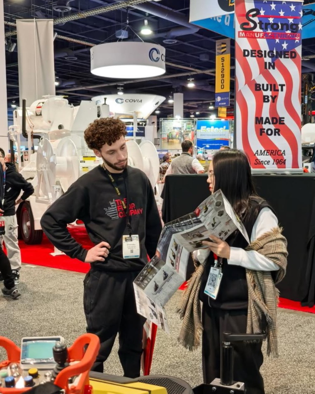 Ethan from The Floor Company speaking with a customer at an industry trade show