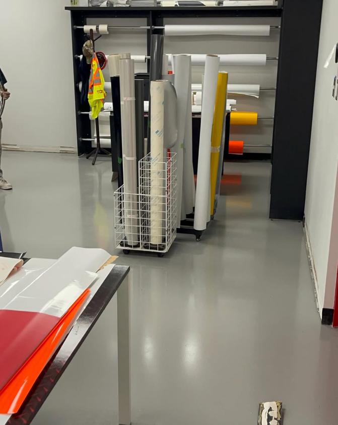 Commercial grey epoxy coating in a print shop with material rolls